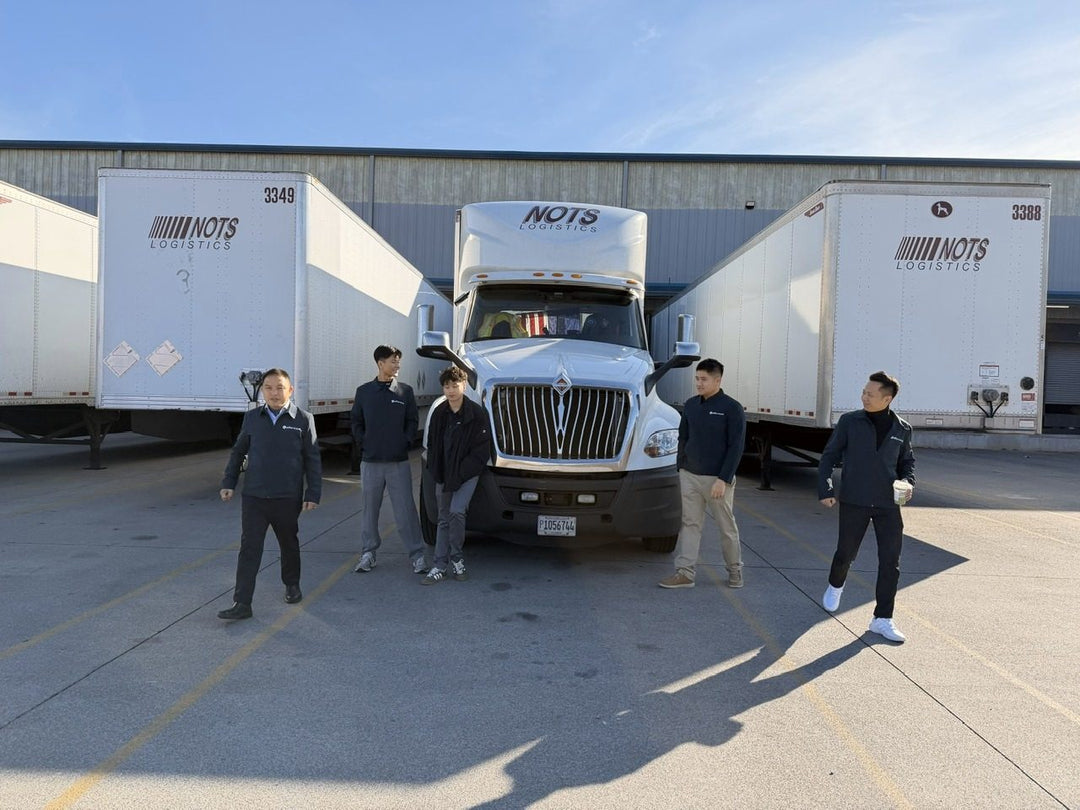 The team outside the Georgia warehouse in front of the logistics company trucks