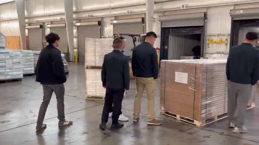 The team looking over an incoming pallet of boxed tops at the Georgia warehouse dock